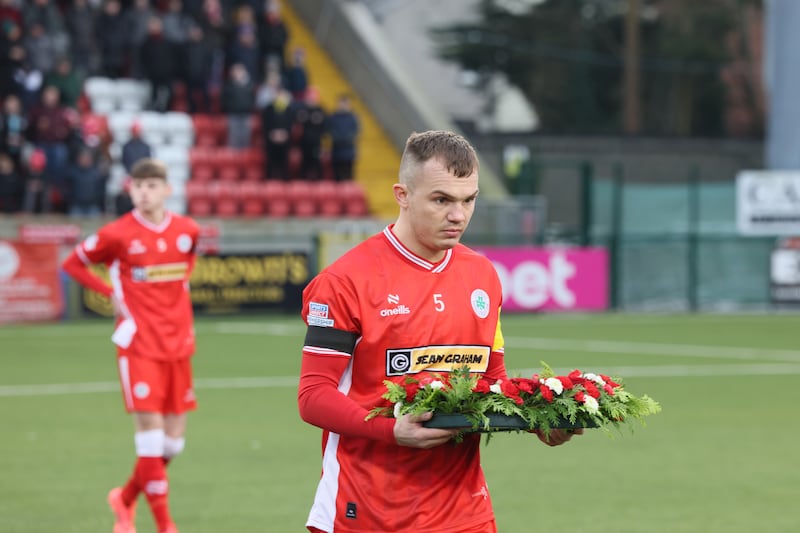 Rory Hale lays a wreath on behalf of his team-mates to honour the late Michael Newberry, the former Cliftonville defender who died suddenly last Monday