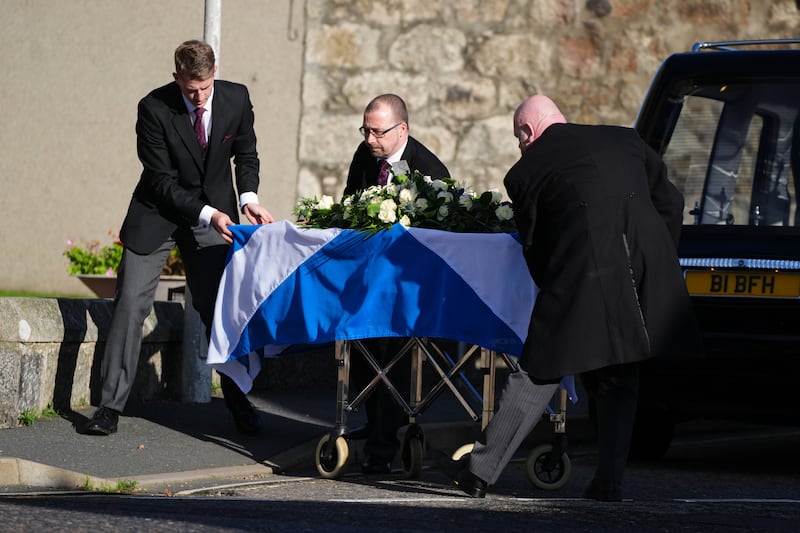 Mr Salmond’s coffin, draped in a Saltire flag, is taken inside the church for his funeral