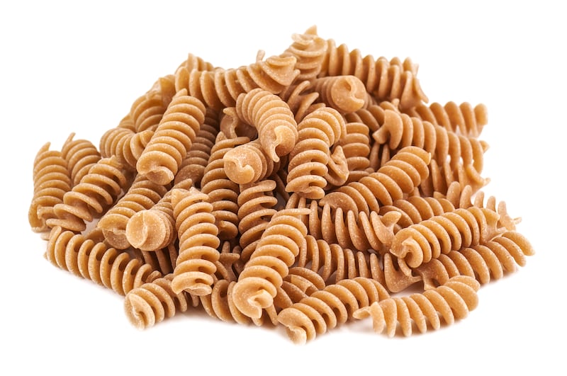 heap of whole wheat pasta on white background