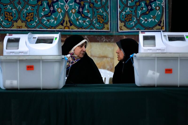 Staff members of a polling station during the parliamentary runoff elections in Tehran on Friday (Vahid Salemi/AP)