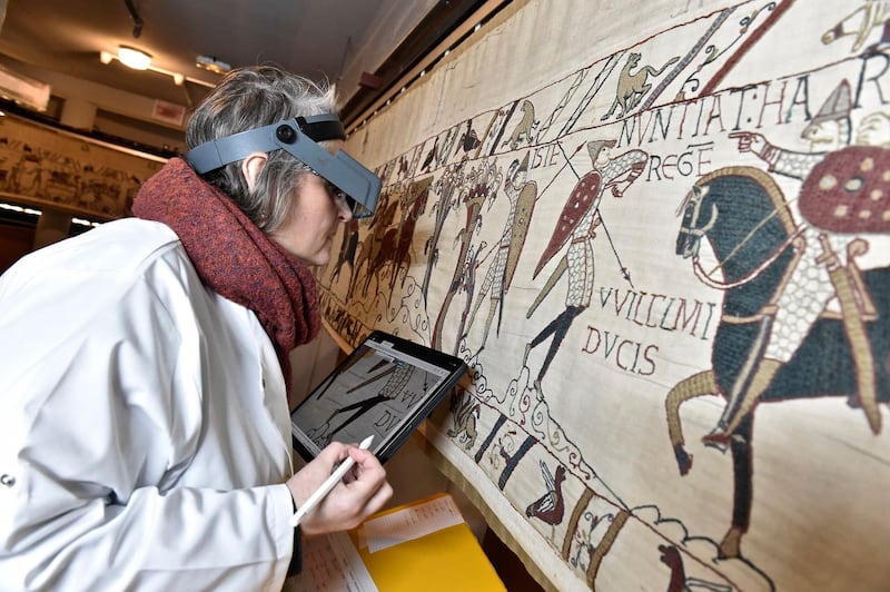 A technician inspecting the tapestry in Bayeux 