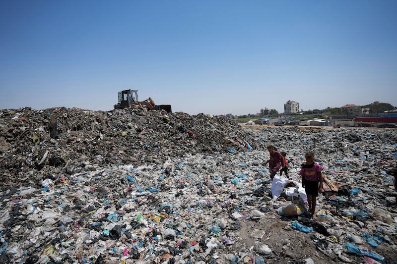 Palestinians sort through trash at a landfill in Nuseirat refugee camp, Gaza Strip (Abdel Kareem Hana/AP)