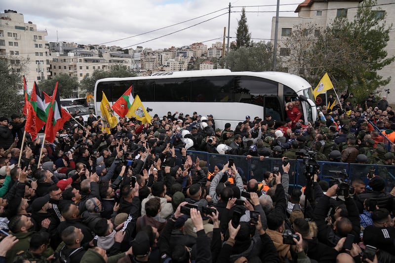 Palestinian prisoners are greeted as they exit a Red Cross bus (Mahmoud Illean/AP)