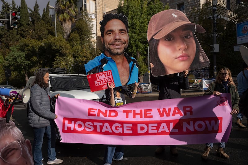 Families and supporters of Israeli hostages held by Hamas in Gaza hold photos of their loved ones during a protest calling for their release (Ohad Zwigenberg/AP)