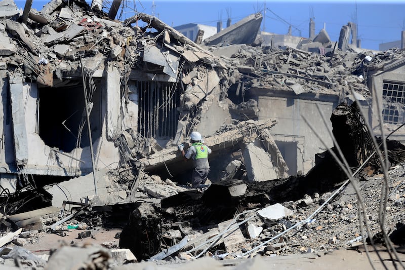 A Hezbollah rescue worker searches for victims amidst the rubble of destroyed buildings hit on Saturday night by Israeli airstrikes, in Nabatiyeh town, south Lebanon (Mohammed Zaatari/AP)