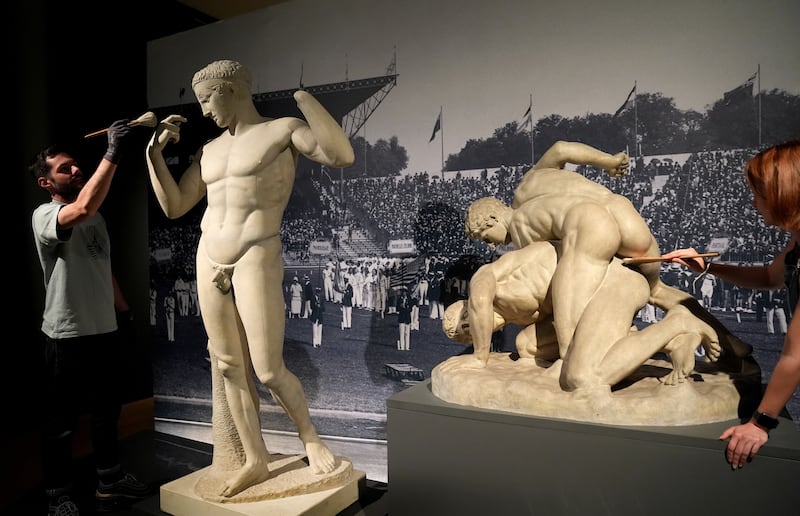 Technicians dust a work which is on display at the Paris 1924: Sport, Art and the Body exhibition at Fitzwilliam Museum