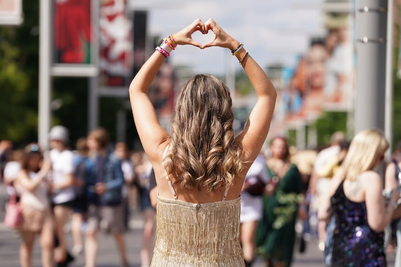 A Taylor Swift fan poses for a photo outside Wembley Stadium in London
