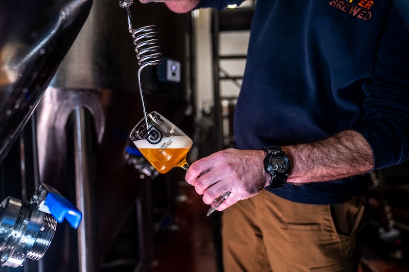 Male pouring beer into a glass.