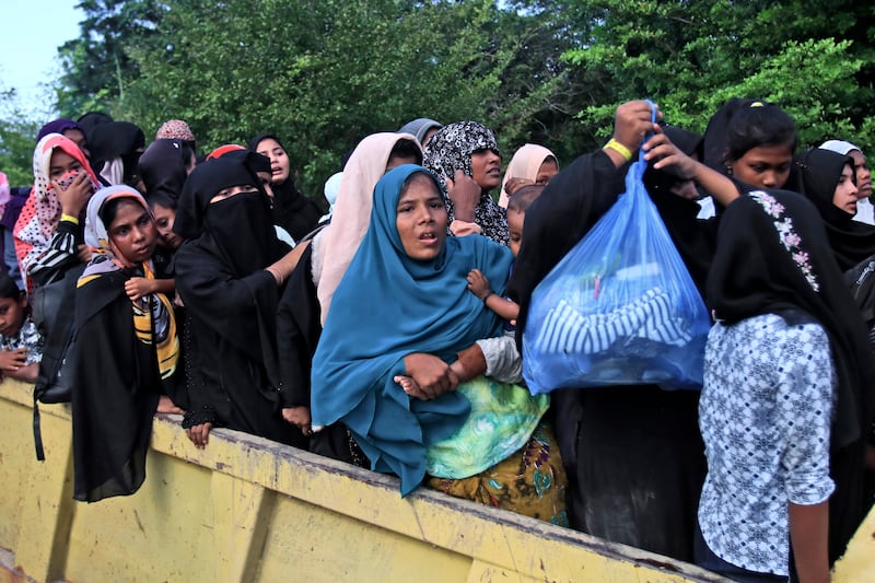 Ethnic Rohingya women and children were forced to board a truck as they are being relocated from their temporary shelter in Aceh (Reza Saifullah/AP)