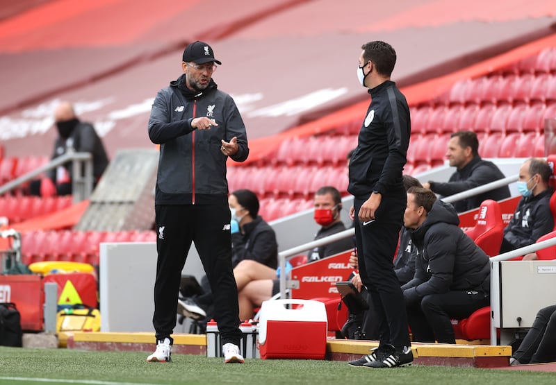 Klopp (left) gestures towards fourth official Coote during a Premier League match at Anfield