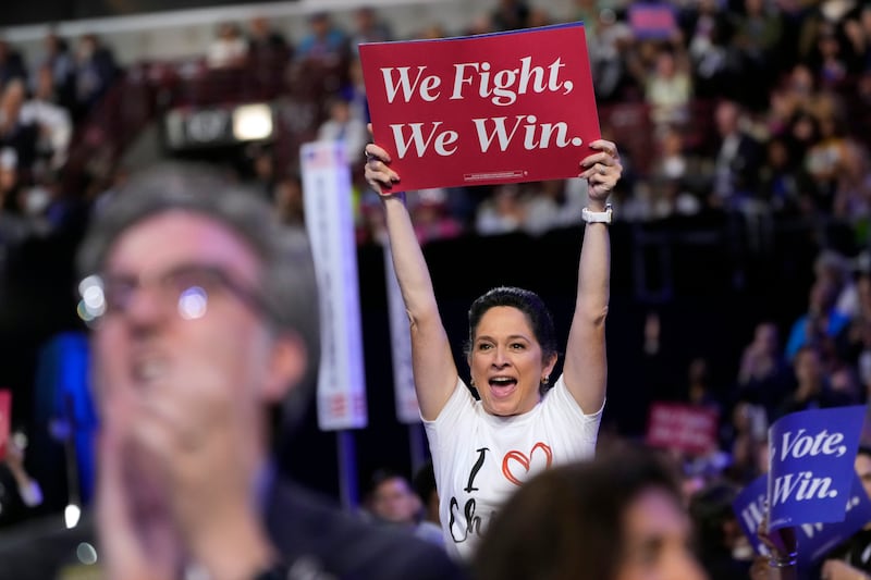 An attendee holds signs during the first day of the Democratic National Convention (Jacquelyn Martin/AP)