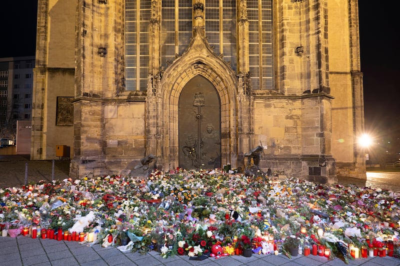 A mass of flowers left in tribute outside St John’s Church in Magdeburg (Sebastian Kahnert/dpa/AP)