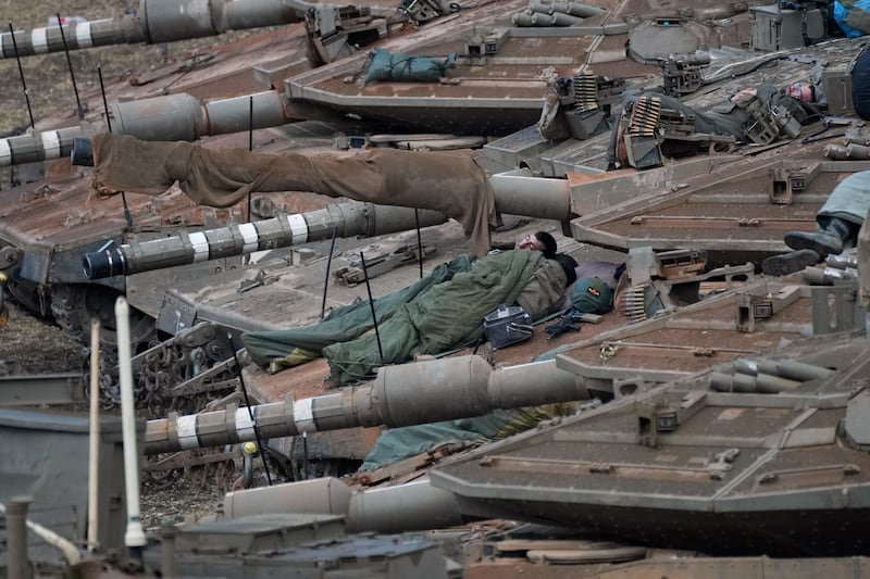 Israeli soldiers sleep on tanks in a staging area in northern Israel near the Israel-Lebanon border (Baz Ratner/AP)