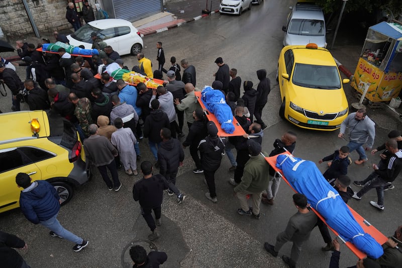 Mourners carry the bodies of four Palestinians killed by an Israeli airstrike in the West Bank city of Tulkarem (Nasser Nasser/AP)