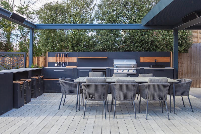 This contemporary outdoor kitchen and dining space is the perfect setting for entertaining guests on summer evenings