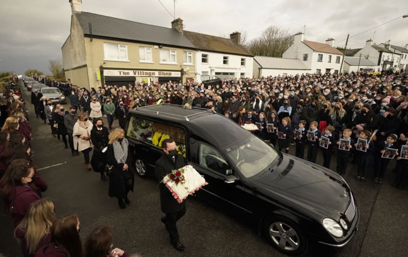 Schoolchildren taught by Ashling Murphy hold photographs of her as the cortege passes by on arrival at St Brigid's Church, Mountbolus, Co Offaly. Picture by Niall Carson/PA Wire&nbsp;