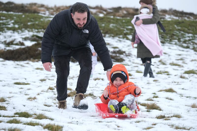 Jack Campbell pushes his son Harvey on a sledge in the snow on Dartmoor in March