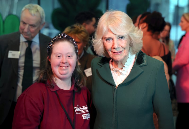 Queen Camilla poses with an usher at a reception during a visit to the Unicorn Theatre, London