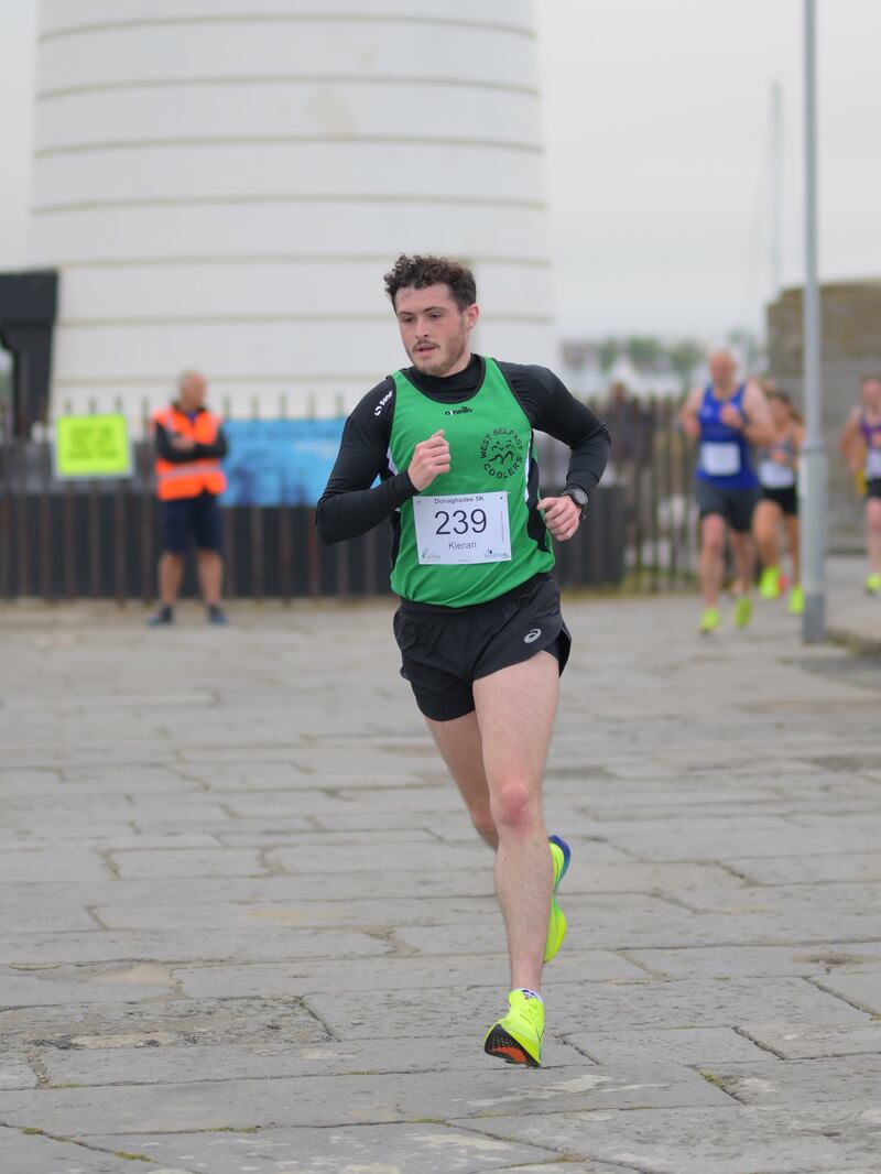 Group of runners in 5k race in front of white lighthouse