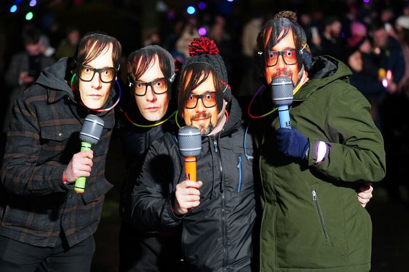 Revellers wear Jarvis Cocker masks ahead of Pulp playing at the New Year Hogmanay Street Party and Concert celebrations in Edinburgh. Picture date: Sunday December 31, 2023.