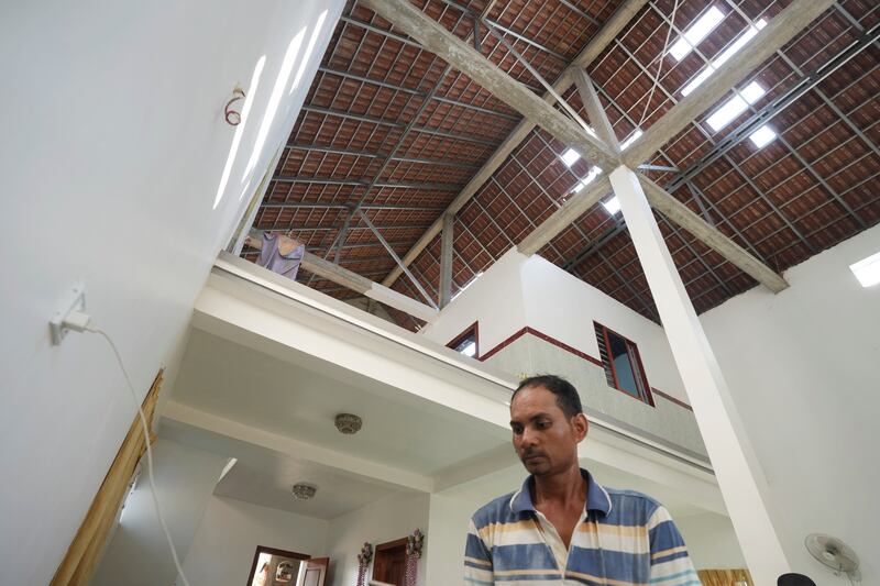 Chim Sothea, a nearby resident, stands under the damaged roof at his house following the explosion (Heng Sinith/AP)