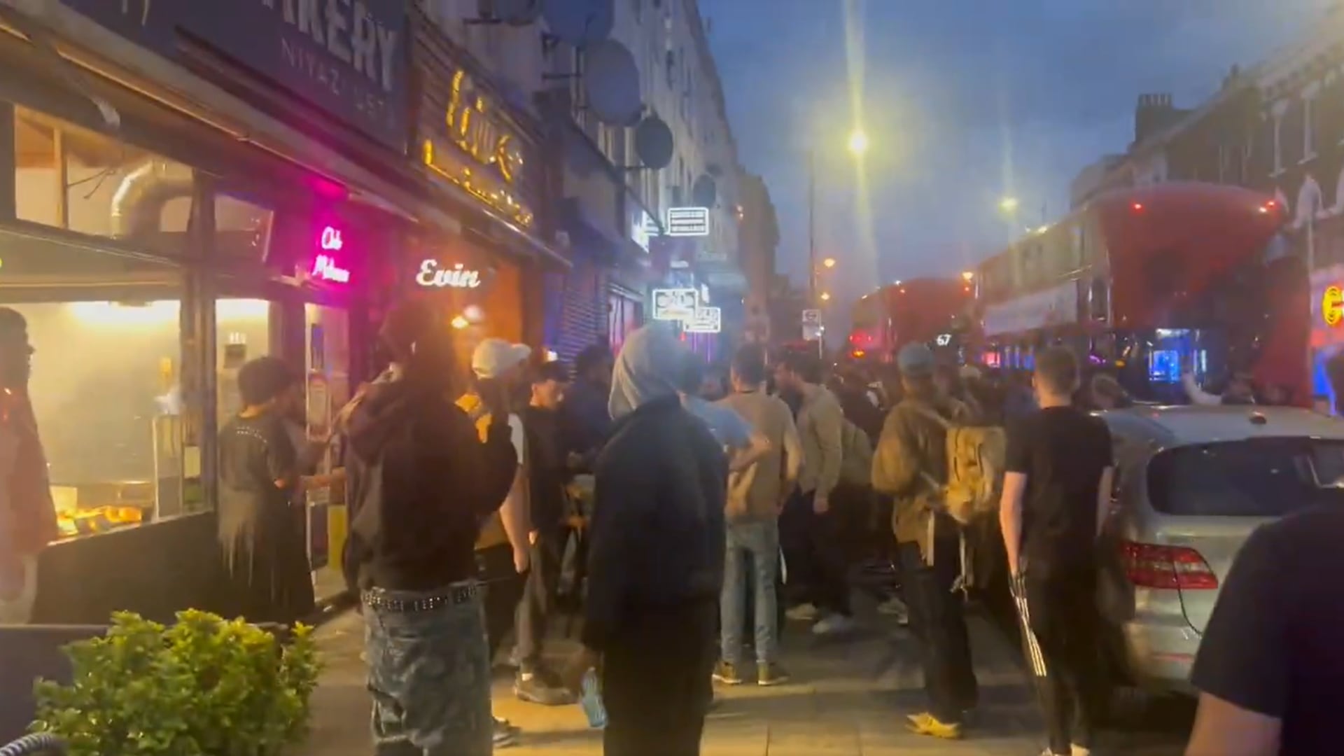 Crowds gathered outside a restaurant in Hackney after a shooting which injured three adults and a child (Ayo Adesina)