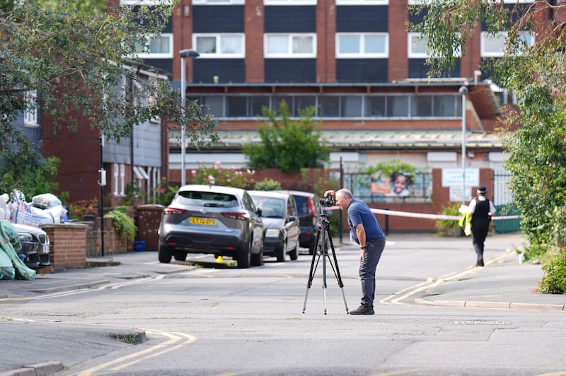 A crime scene photographer at the scene in Stellman Close in Hackney