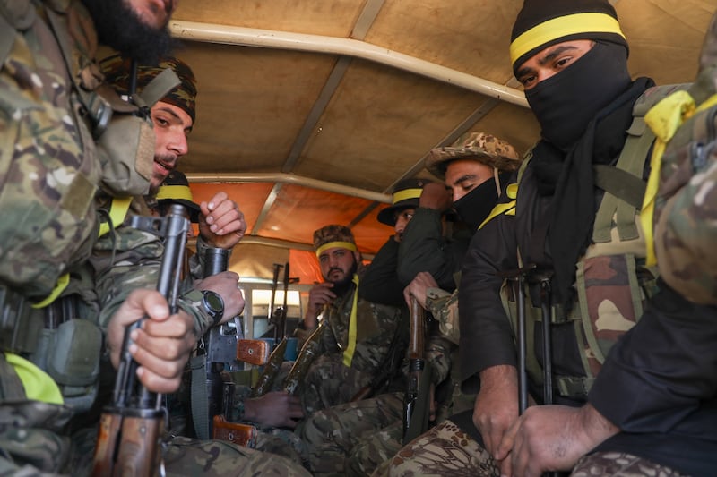 Syrian opposition fighters ride in a truck as they enter the village of Anjara, on the western outskirts of Aleppo, Syria (Omar Albam/AP)