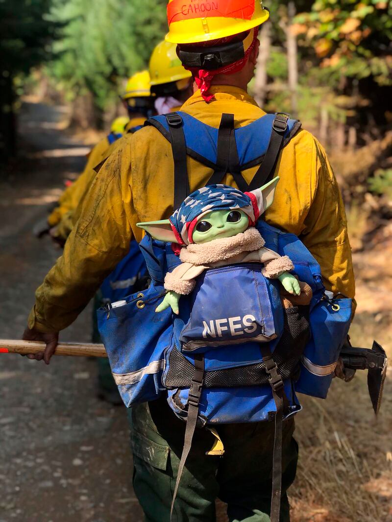 A Baby Yoda doll hitches a ride in the backpack of an Oregon Air National Guard firefighter