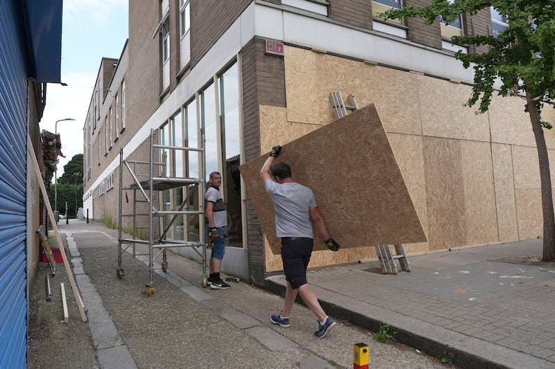 Workers were seen boarding up shop fronts in North Finchley, London, on Wednesday afternoon