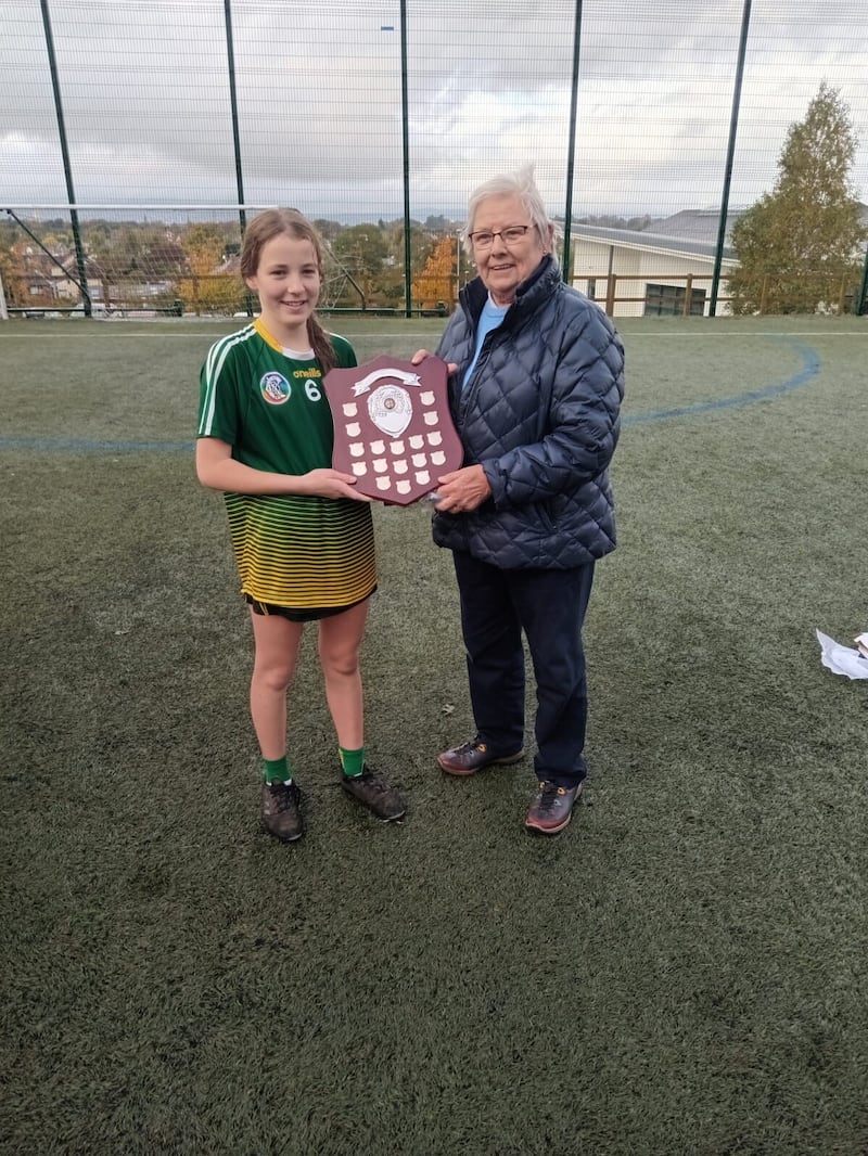 Daisy Tumilty, captain of Sacred Heart, is presented with the Celine McAteer Shield by Celine's twin sister Anne