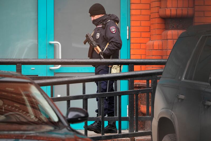 A police officer stands guard in the yard of the apartment block (AP)