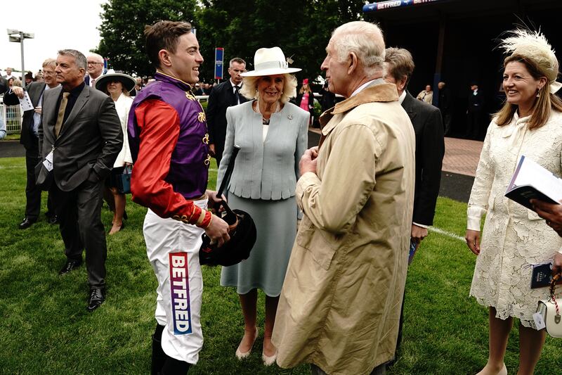 Charles and Camilla chat to their jockey James Doyle before the race