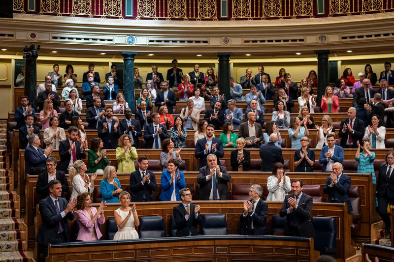 Prime Minister Pedro Sanchez, foreground left, applauds after the lower house of the Spanish Parliament approved the amnesty law (Bernat Armangue/AP)