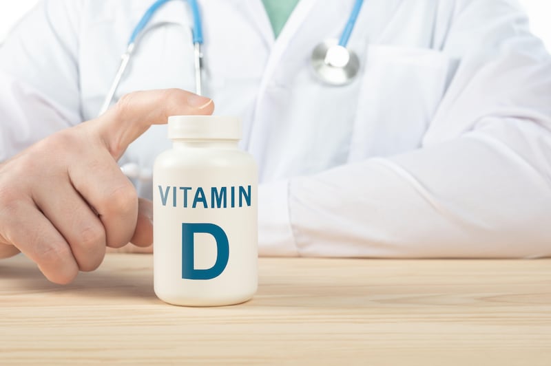 Close up photo of doctor next to a box of vitamin D tablets