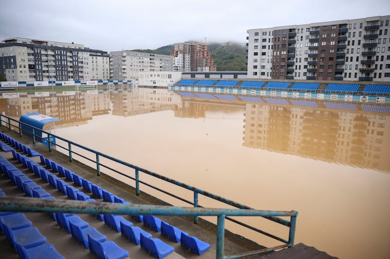 Apartment buildings are reflected at a flooded football field after heavy rain in the village of Kiseljak in northern Bosnia (Armin Durgut/AP)