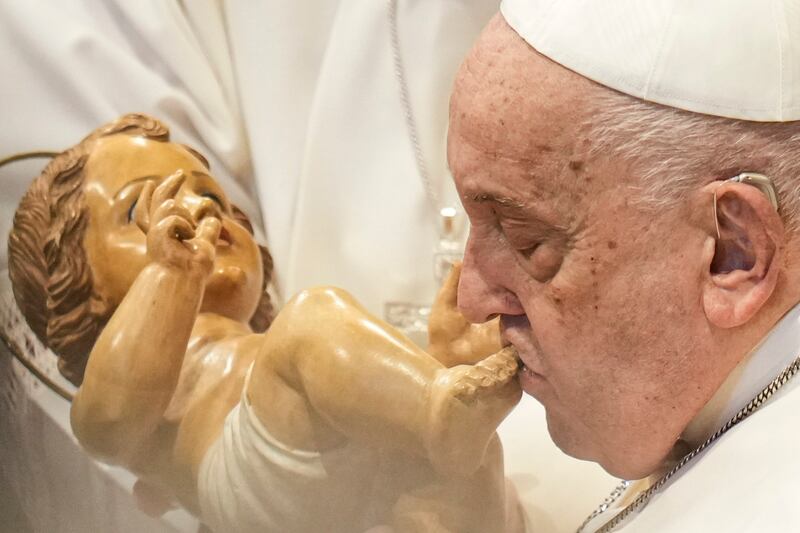 Pope Francis kisses a wooden statuette of the infant Jesus at the end of the New Year’s Day Mass in St Peter’s Basilica (Andrew Medichini/AP)