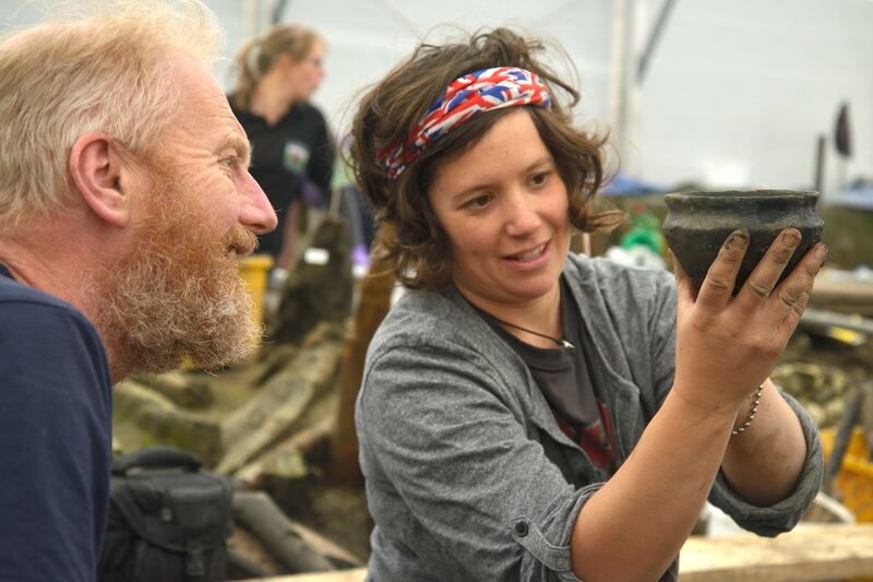 Archaeologists examine a Bronze Age bowl.