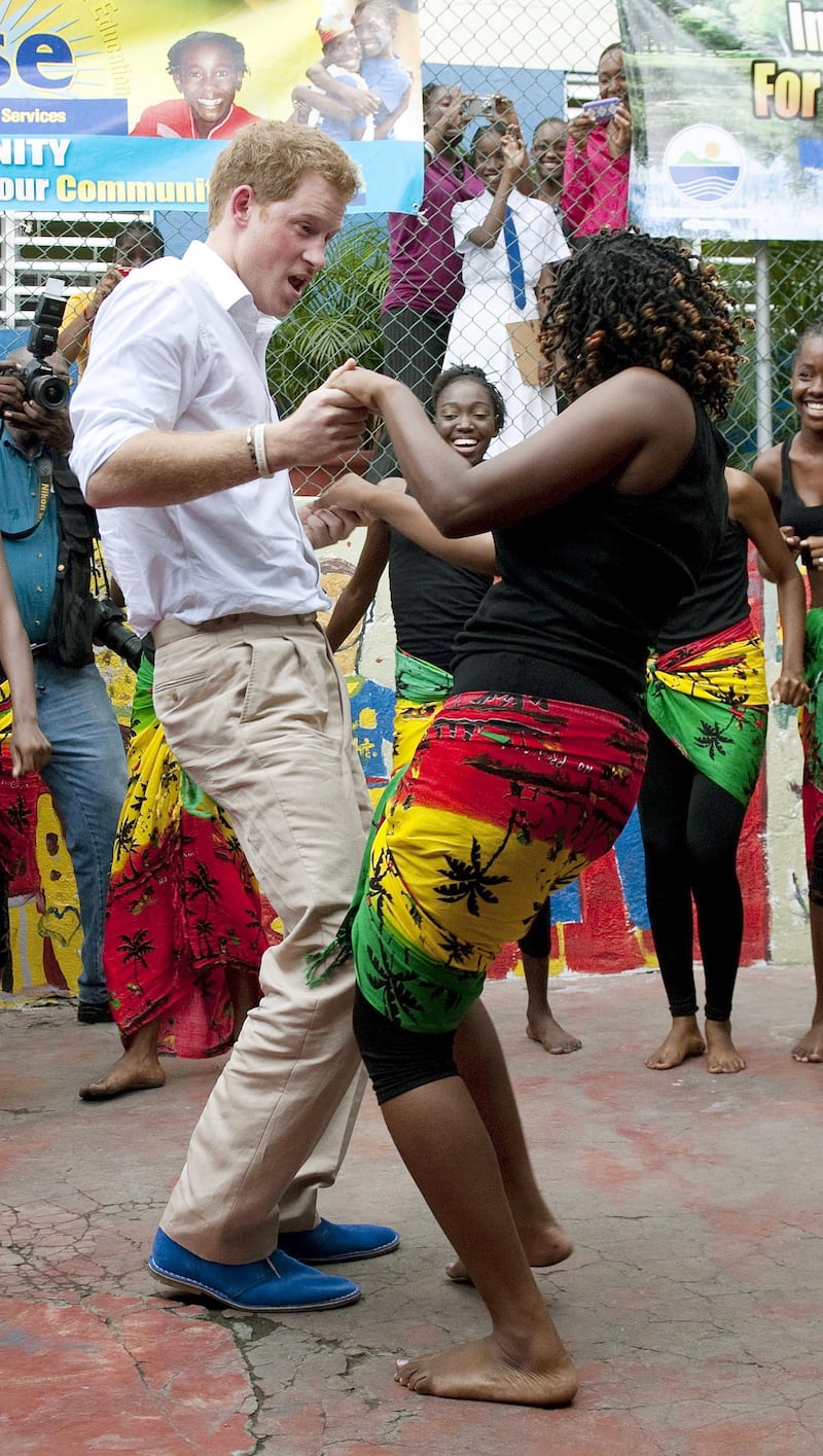 Harry dances with a woman during a visit to the Rise Life charity project, in Jamaica, as part of a Diamond Jubilee tour where he is representing his grandmother