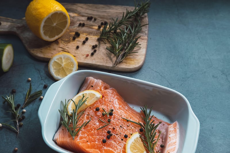 Fresh and raw salmon with lemon and rosemary ready to cook in the oven