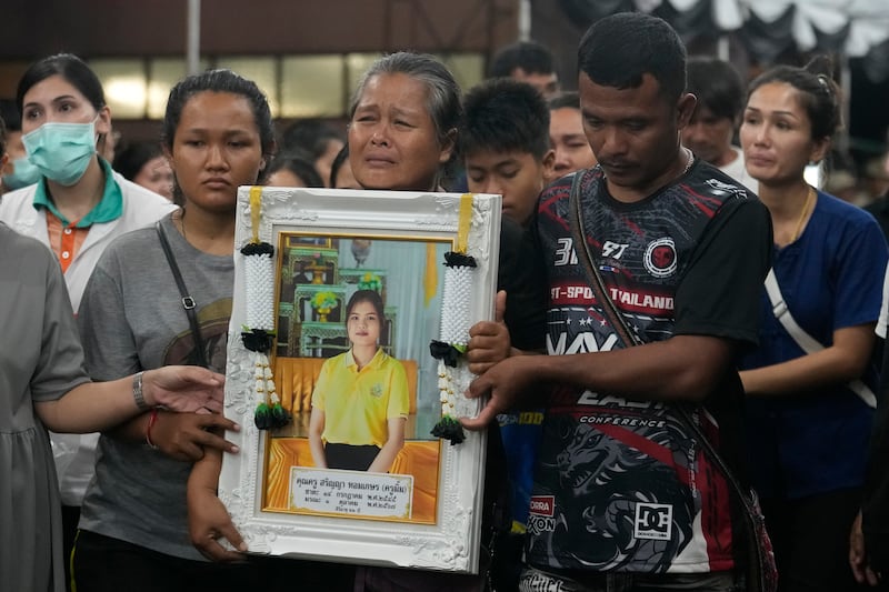 Victims’ relatives carry portraits of the victims of a bus fire in a procession at Wat Khao Phraya Sangkharam School Lan Sak, Uthai Thani province, Thailand (Sakchai Lalit/AP)