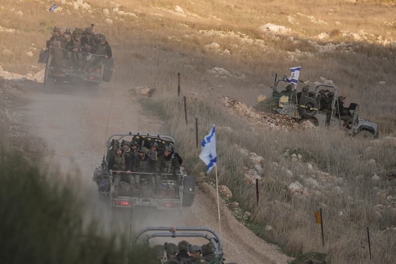 Israeli soldiers cross the security fence moving towards the so-called Alpha Line that separates the Israeli-annexed Golan Heights from Syria (Matias Delacroix/AP)