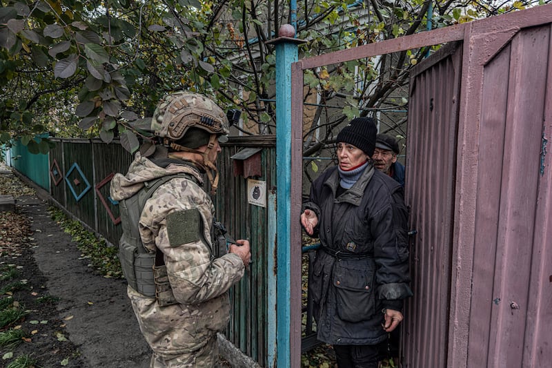 Pipa Vasyl, a policeman of the ‘White Angels’, tries to convince a local woman to evacuate from Kurakhove, Donetsk region, Ukraine (Anton Shtuka/AP)