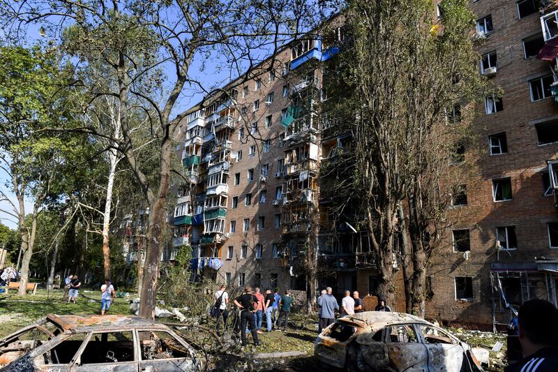 People gather at an apartment building in Kursk, Russia, damaged by Ukrainian shelling (AP)