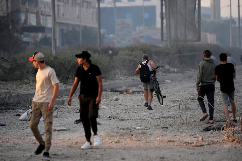 People walk on the debris of destroyed buildings in Dahiyeh, Beirut, Lebanon, after Israeli air strikes (Hussein Malla/AP)