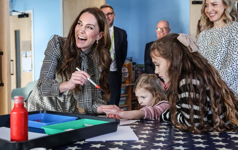 The Princess of Wales paints the hand of four-year-old Maggie during a visit to the Ty Hafan hospice in Sully, near Cardiff, South Wales