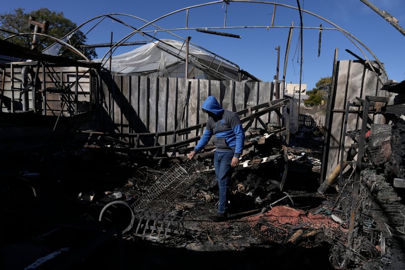 A Palestinian youth sifts through the aftermath of an attack by Israeli settlers in the West Bank village of Jinsafut (AP Photo/Majdi Mohammed)