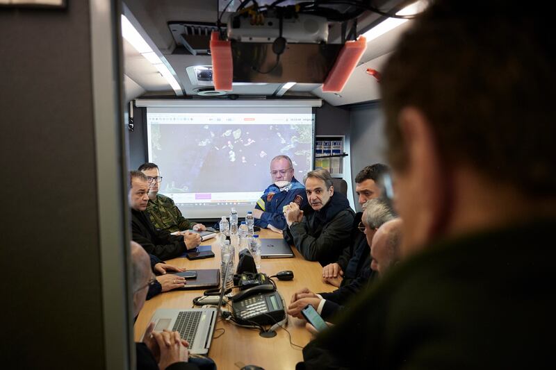 Kyriakos Mitsotakis, centre, gets an update during his visit to the temporary headquarters of emergency services on Santorini (Dimitris Papamitsos/Greek Prime Minister’s Office via AP)