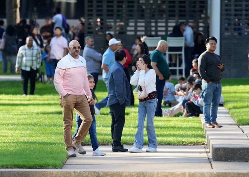 A woman holds her face as she waits with others outside Lakewood Church, Texas following a shooting on Sunday (Karen Warren/AP)