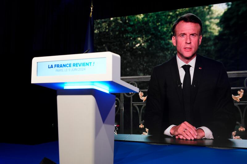French President Emmanuel Macron appears on a television screen at the French far-right National Rally party election night headquarters in Paris (Lewis Joly/AP)